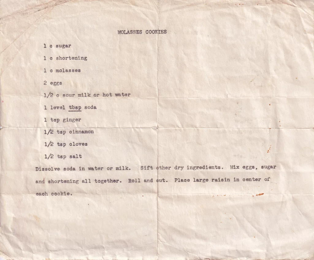 Molasses cookies recipe typed on paper with molasses, ginger, cinnamon, and cloves